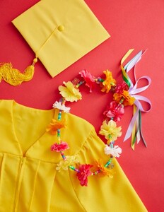 yellow grad gown and cap with lei